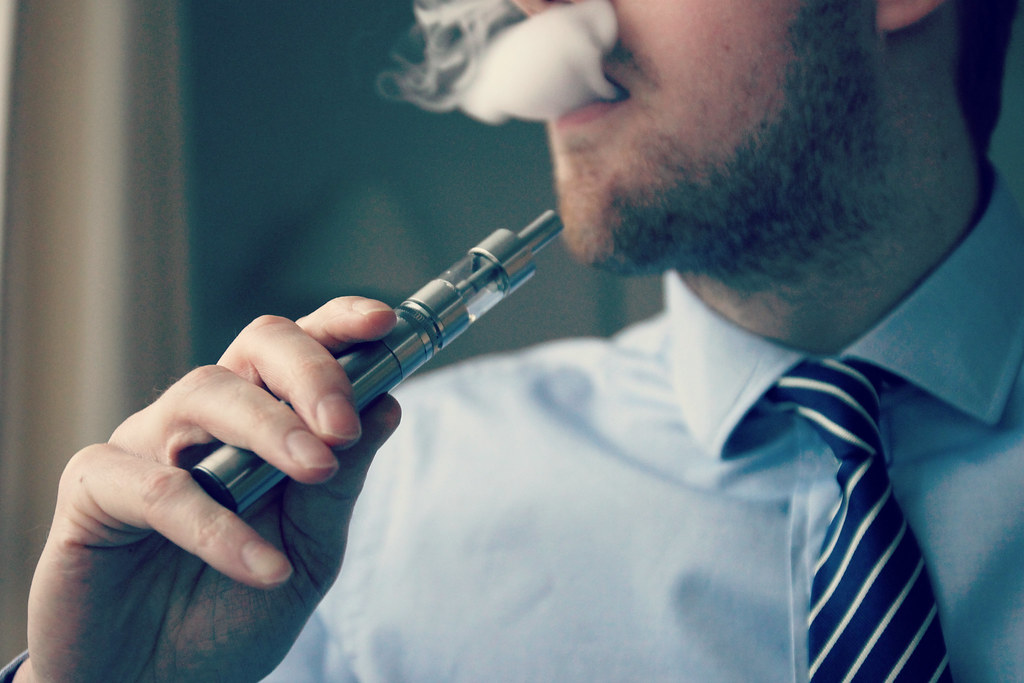 Man exhaling vapor from an e-cigarette